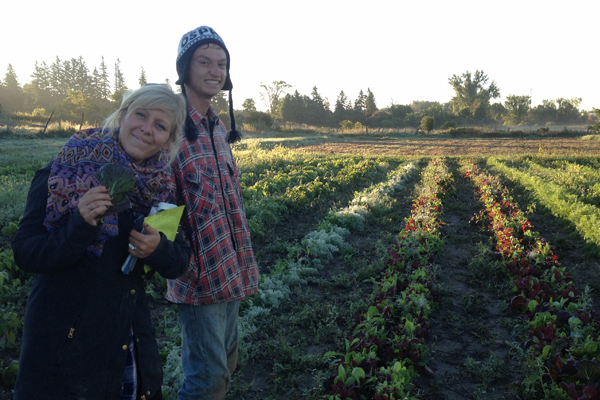 farmers smiling in front of planted garden plot